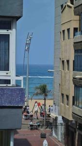 Una vista del océano desde un edificio con gente en la playa. en La Fontanilla, Playa de las Canteras, en Las Palmas de Gran Canaria