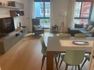 Una sala de estar con un sofá, una mesa y sillas. en La Fontanilla, Playa de las Canteras, en Las Palmas de Gran Canaria