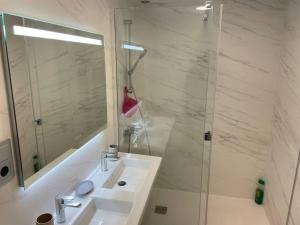 a bathroom with a sink and a shower with a mirror at La Fontanilla, Playa de las Canteras in Las Palmas de Gran Canaria