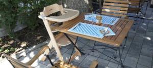 a wooden table and chairs on a patio with a table and a chair at Pension Obstgarten in Laupheim