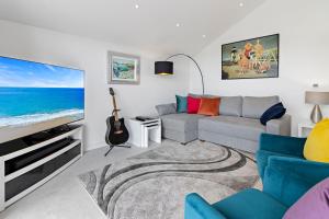 ein Wohnzimmer mit einem Sofa und einem Flachbild-TV in der Unterkunft Anchor View at Grand Banks, Teignmouth in Teignmouth