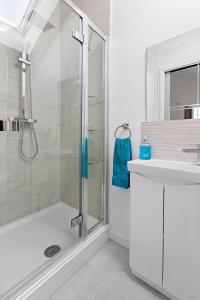 y baño con ducha y lavamanos. en Anchor View at Grand Banks, Teignmouth, en Teignmouth