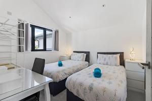 1 Schlafzimmer mit 2 Betten und einem Schreibtisch in der Unterkunft Anchor View at Grand Banks, Teignmouth in Teignmouth