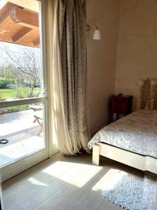 a bedroom with a bed next to a large window at Boccadibacco in San Pietro in Cariano