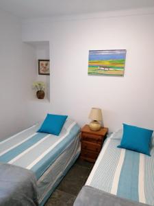 a bedroom with two beds and a table with a lamp at CASA DA ALAMEDA in Nisa
