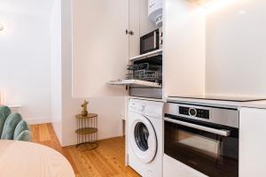 une cuisine blanche avec un lave-linge et un sèche-linge. dans l'établissement Cozy Hideout I by Innkeeper, à Lisbonne