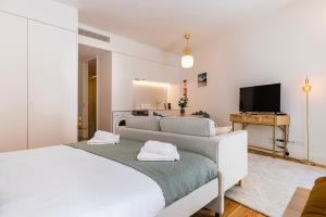 - une chambre avec un grand lit blanc et une télévision dans l'établissement Cozy Hideout I by Innkeeper, à Lisbonne