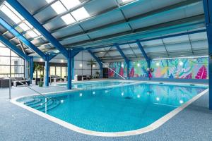 a large swimming pool in a building at Platinum lodge on Carlton Meres holiday Park in Rendham