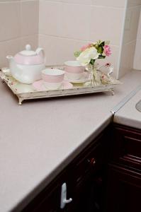 a tray with dishes and a tea set on a counter at 33SM Dreams Unlimited Serviced Accommodation- Staines - Heathrow in Stanwell