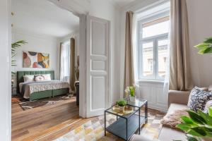 ein Wohnzimmer mit einem Bett und einem Tisch in der Unterkunft Luxurious Art Deco Residence in the Heart of Budapest in Budapest