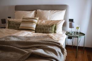 a bed with white sheets and pillows and a table at Villa Cavaion in Cavaion Veronese