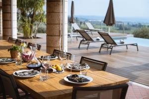 un tavolo in legno con bicchieri da cibo e vino su un patio di Villa Cavaion a Cavaion Veronese