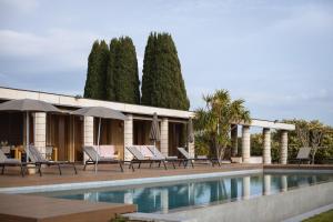 un resort con piscina, sedie e alberi di Villa Cavaion a Cavaion Veronese