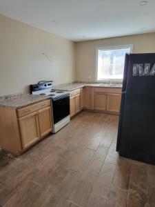 an empty kitchen with a stove and a window at Katahdin's Shadow Lodge in Linneus