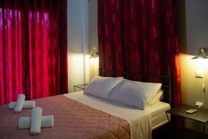 奇亞頓的住宿－"Tsiftsis" City Apartments，一间卧室配有红色窗帘和一张带两个枕头的床