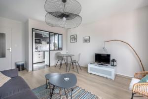 - un salon avec un canapé et une table dans l'établissement Appartement moderne a 250 m de la mer, au Pouliguen