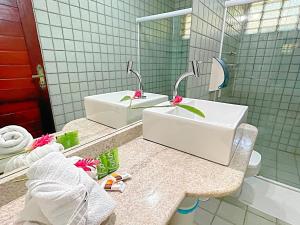 a bathroom with a sink and a toilet and a mirror at Eco Pousada Paraíso dos Coqueirais in Japaratinga
