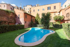 una piscina nel mezzo di un cortile con edifici di iFlat Loft&Pool in Trastevere a Roma