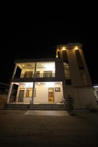 a large white house with lights on it at night at The Sky Comfort Shiv Ashray Resort in Nāthdwāra