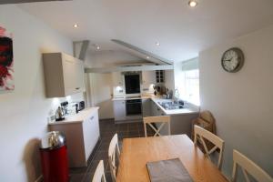a kitchen and dining room with a table and a clock at Calley House, Hutton remote cottage with hot tub, 10 minutes to Ullswater in Penruddock
