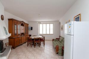 een keuken en eetkamer met een tafel en een koelkast bij Casa con giardino in Posada