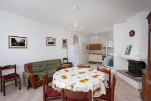 een keuken en een woonkamer met een tafel en stoelen bij Casa con giardino in Posada