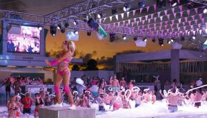 a woman standing on a podium in front of a crowd at Riu Palace Bavaro - All Inclusive in Punta Cana