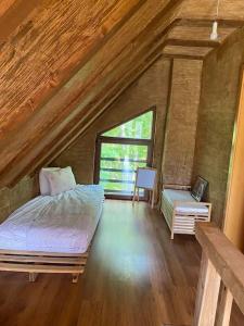 an attic bedroom with a bed and a window at Cozy 3 bedroom mountain villa with scenic views in Novoberdo