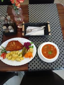 una mesa con un plato de comida y un tazón de sopa en Zajazd Reczyn - Nowy Reczyn 16, 