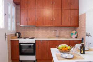 a kitchen with wooden cabinets and a bowl of fruit on a counter at "Tsiftsis" City Apartments in Kiaton