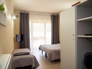 a hotel room with two beds and a window at Tarchon Luxury B&B in Tarquinia