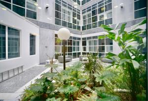 an office building with a courtyard with plants at Large Balcony Apartment with City View by DH ApartHotels in Peterborough