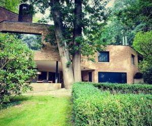 una casa di mattoni con un albero di fronte di B&B Miranoza a Oud-Heverlee