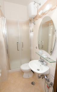a bathroom with a toilet and a sink and a shower at Tarchon Luxury B&B in Tarquinia