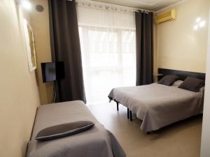 2 camas en una habitación con ventana en Tarchon Luxury B&B, en Tarquinia