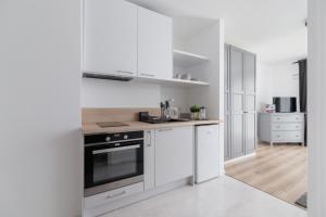 a kitchen with white cabinets and a stove top oven at Elegant Pet-Friendly Studio in Krakow by Renters in Krakow