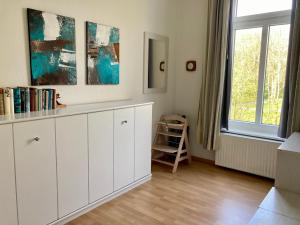 - un salon avec une armoire blanche et une fenêtre dans l'établissement Residenz am Rosengarten 16, à Wangerooge