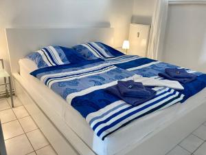 Bett mit blau-weiß gestreifter Bettwäsche und Handtüchern in der Unterkunft Haus Seeluft Whg 11 in Wangerooge