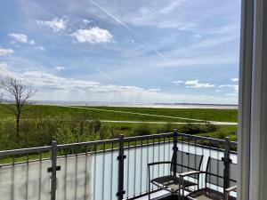 a balcony with two chairs and a view of the ocean at Ferienhaus Grodenblick Sanddorn Whg 3 in Wangerooge