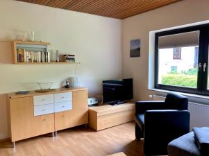 ein Wohnzimmer mit einem TV und einem Stuhl in der Unterkunft Haus Wilhelmi Wilhelmi Whg 2 in Wangerooge