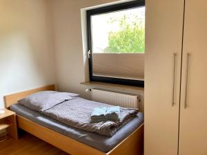 ein kleines Schlafzimmer mit einem Bett und einem Fenster in der Unterkunft Haus Wilhelmi Wilhelmi Whg 2 in Wangerooge