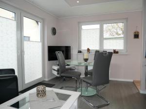 una sala de estar con una mesa y sillas en Bungalow "Vera", en Ostseebad Koserow