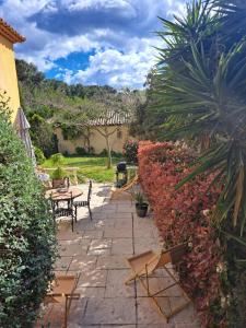 イエールにあるRez de jardin villa Presqu'ile de Giensの庭園内のパティオ(テーブル、椅子付)