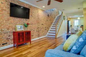 a living room with a brick wall and a tv at Quaint Baltimore Townhouse about 1 Mi to Inner Harbor! in Baltimore