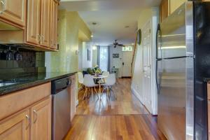 a kitchen with wooden cabinets and a table with chairs at Quaint Baltimore Townhouse about 1 Mi to Inner Harbor! in Baltimore