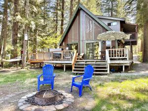 two blue chairs and a fire pit in front of a cabin at Jack's Cabin by NW Comfy Cabins in Leavenworth