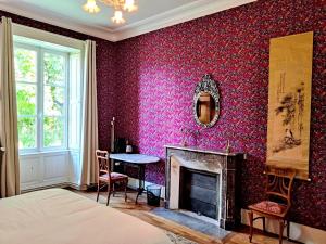 a bedroom with a bed and a fireplace and a table at VALLÉE 1900 in Torfou