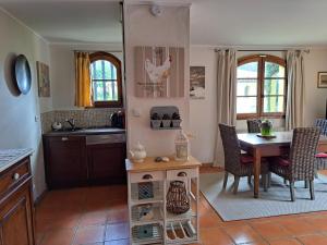 une cuisine avec une table et une cuisine avec un poulet sur le mur dans l'établissement Rez de jardin villa Presqu'ile de Giens, à Hyères