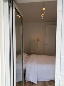 a bedroom with a white bed and a mirror at Braga Centro, Totalmente remodelado em 2023! in Braga