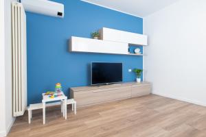 a living room with a tv on a blue wall at Nida 18 in Cattolica